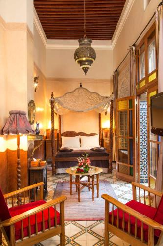 a bedroom with a bed and a table and chairs at Dar El Kébira in Rabat