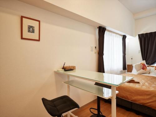 a room with a desk and a bed and a bed at M´s Stay Okinawa in Chatan