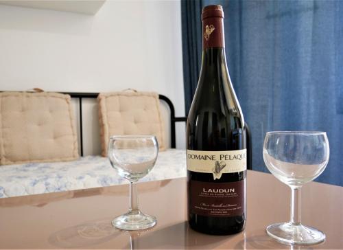 a bottle of wine and two glasses on a table at le Travertin in Avignon