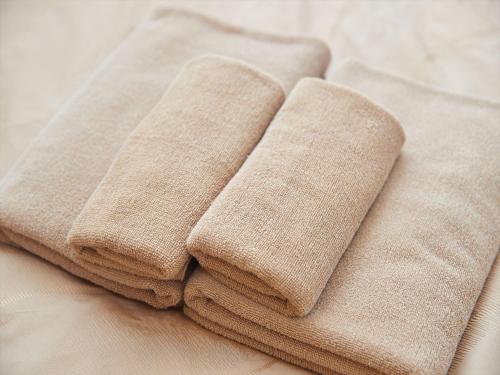 three brown towels sitting on top of a table at M´s Stay Okinawa in Chatan