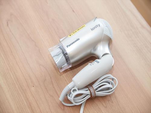 a white electric hair dryer on a wooden table at M´s Stay Okinawa in Chatan