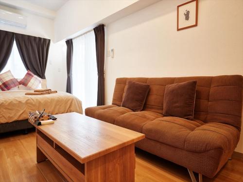 a living room with a couch and a bed at M´s Stay Okinawa in Chatan