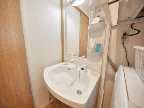 a bathroom with a sink and a mirror at M´s Stay Okinawa in Chatan