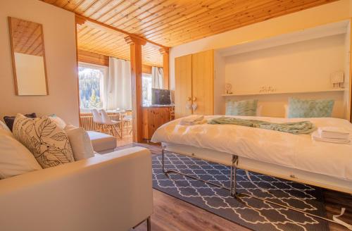 a bedroom with two beds and a living room at Miraflor Sonja by Arosa Holiday in Arosa