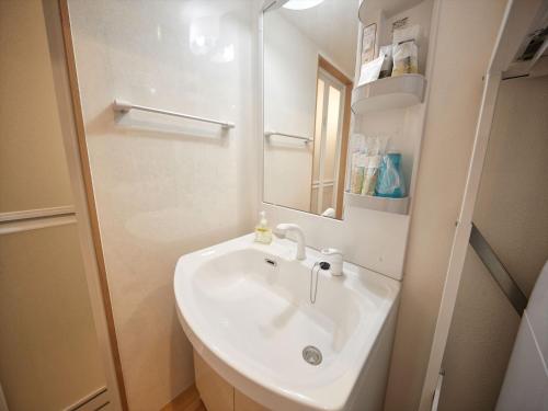 a bathroom with a sink and a mirror at M´s Stay Okinawa in Chatan