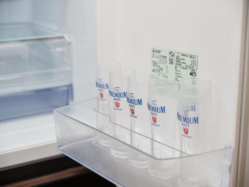 a refrigerator filled with lots of plastic containers at M´s Stay Okinawa in Chatan