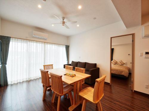 a living room with a table and chairs and a couch at M´s Stay Okinawa in Chatan