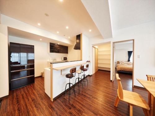 a kitchen and living room with a bar and a bed at M´s Stay Okinawa in Chatan