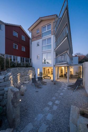 a building with benches in front of a building at Appartementhotel Röhrenbach in Immenstaad am Bodensee