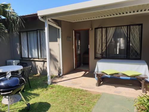 a room with a bed and a grill on a patio at 11 Villa Del Sol in Amanzimtoti