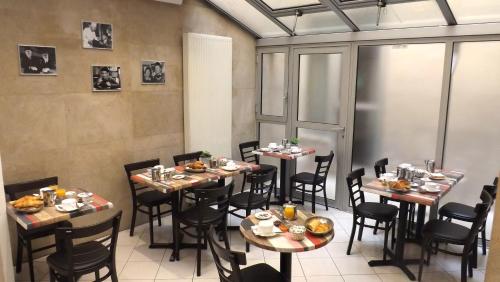 een restaurant met tafels en stoelen met eten erop bij Hôtel de la Place des Alpes in Parijs