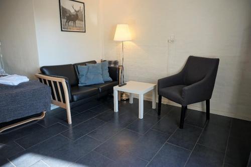 カーテミンドにあるKerteminde Byferie - Hyrdevej 83, 85Kのソファ、椅子2脚、テーブルが備わる客室です。