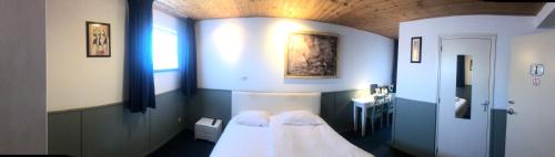 a room with a bed and a sink in it at Hotel Verhoeven in Uden
