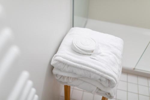 a stack of white towels on a rack in a bathroom at Vier Häuser in Norderney