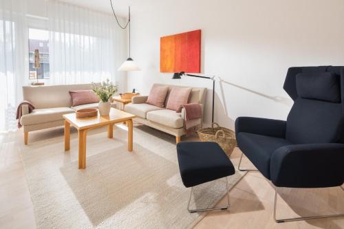a living room with a couch and a chair at Vier Häuser in Norderney