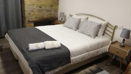 a bedroom with a bed with two pillows on it at House Diogo in Bemposta