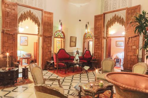 a living room with chairs and a table in a room at Dar El Kébira in Rabat