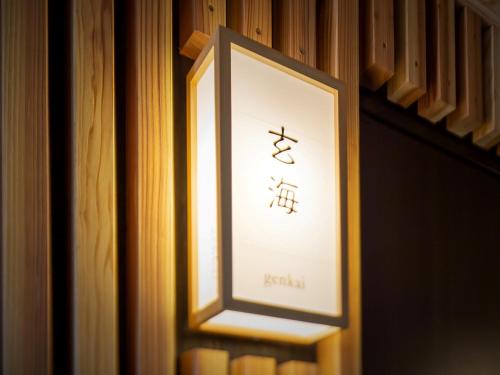 a sign for a hotel on a wall at Hakata-no-Yado Tsurezure-Ann in Fukuoka