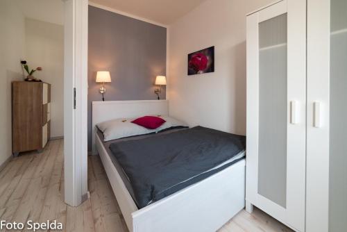 um pequeno quarto com uma cama num quarto em Tom´s Ferienappartements em Tabarz