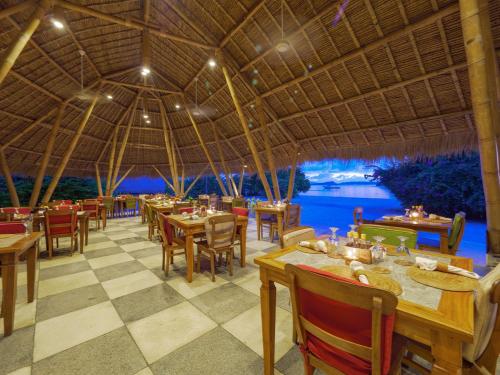 a restaurant with tables and chairs and a view of the water at Komodo Resort in Sebayur