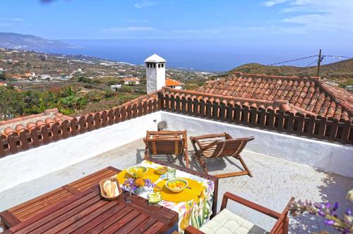 a patio with a table and chairs on a roof at El Molino in Mazo
