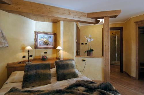 1 Schlafzimmer mit einem Bett und einem Schreibtisch mit 2 Stühlen in der Unterkunft Hotel Da Compagnoni in Breuil-Cervinia