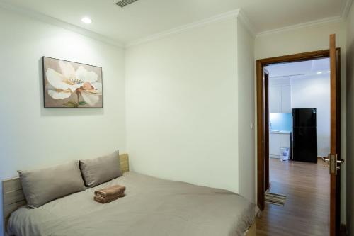a bed in a bedroom with a picture on the wall at Full House Times City in Hanoi