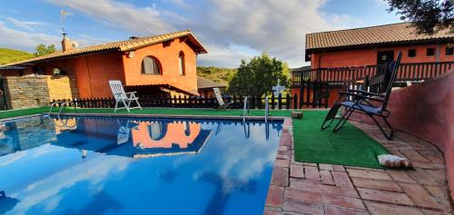 una casa con piscina frente a una casa en Hostal Rural Casa Pedro, en San Martín de Unx