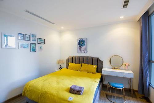 a small bedroom with a yellow bed and a mirror at Full House Times City in Hanoi