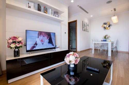 a living room with a flat screen tv on a wall at Full House Times City in Hanoi