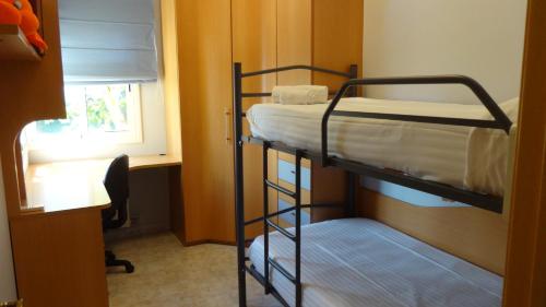 ein Etagenbettzimmer mit zwei Etagenbetten und einem Fenster in der Unterkunft R88 Casa Alegre in Segur de Calafell