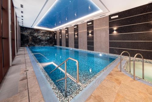 a swimming pool in a hotel room with a ceiling at Spa Hotel ULRIKA in Karlovy Vary