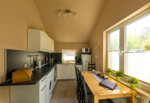 a kitchen with a wooden table and a large window at Ferienhaus Vergissmeinnicht in Papenburg