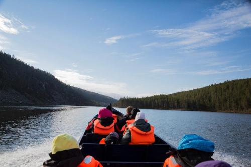 a group of people in a boat on a river at Aurora Village Ivalo in Ivalo