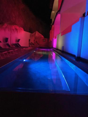a swimming pool with blue and purple lights at La Casa E Il Mare, Private Bay Hotel in Mattinata