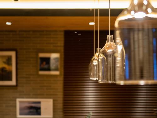 a chandelier with glass bottles hanging from a ceiling at Super Hotel Okayama Station Higashiguchi in Okayama