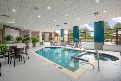 a pool in a hotel lobby with tables and chairs at Holiday Inn Huntsville - Research Park by IHG in Huntsville