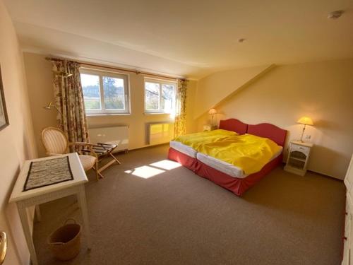a bedroom with a bed and a desk and a chair at Gut Settin am See - Ferienhäuser in Settin