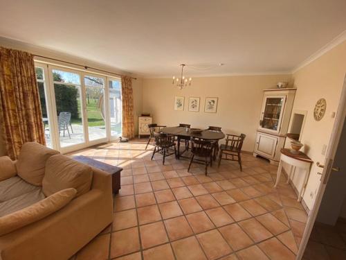 a living room with a couch and a table and chairs at Gut Settin am See - Ferienhäuser in Settin