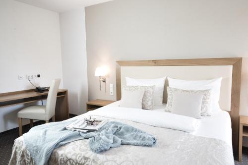 a bedroom with a large white bed with a desk at Boardinghaus an der Sempt - Wohlfühlen auf dem Lande in Erding