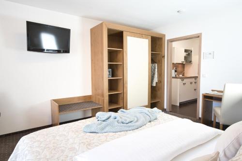 a bedroom with a bed with a tv on the wall at Boardinghaus an der Sempt - Wohlfühlen auf dem Lande in Erding