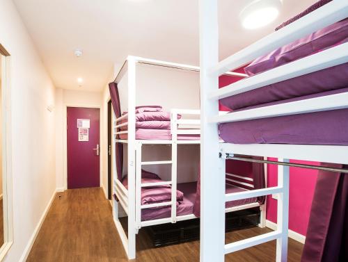 een kamer met 2 stapelbedden met paarse lakens bij Safestay London Elephant & Castle in Londen