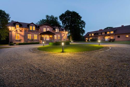 a house with lights in the middle of a driveway at Gut Settin am See - Ferienhäuser in Settin