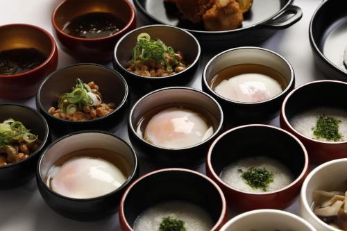 a group of bowls filled with food on a table at Dormy Inn Kawasaki Natural Hot Spring in Kawasaki