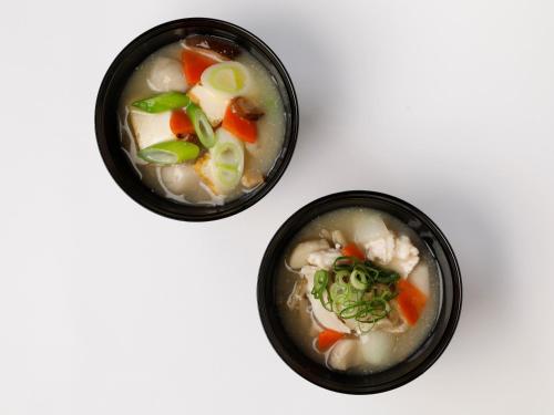 two bowls of soup on a white table at Dormy Inn Kawasaki Natural Hot Spring in Kawasaki