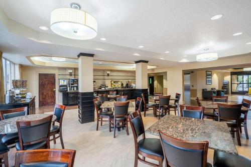 a restaurant with tables and chairs and a bar at La Quinta by Wyndham Hot Springs in Hot Springs