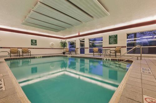 a pool in a hotel with chairs and tables at La Quinta by Wyndham Boise Airport in Boise