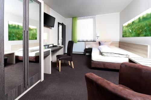 ein Hotelzimmer mit einem Bett und einem Schreibtisch in der Unterkunft Hotel Pfennigskrug in Herford