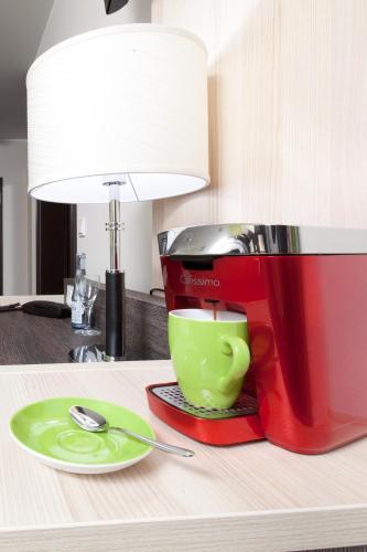 a red coffee maker and a green cup on a table at Hotel Pfennigskrug in Herford