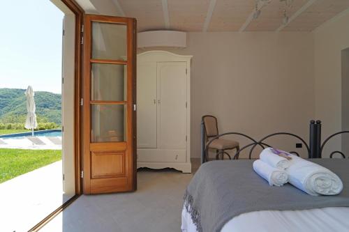 Villa La Braja في Licciana Nardi: غرفة نوم بسرير وباب زجاجي منزلق